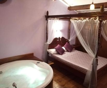 Habitación doble con bañera de hidromasaje privada cerca de la cama de este establecimiento rural.