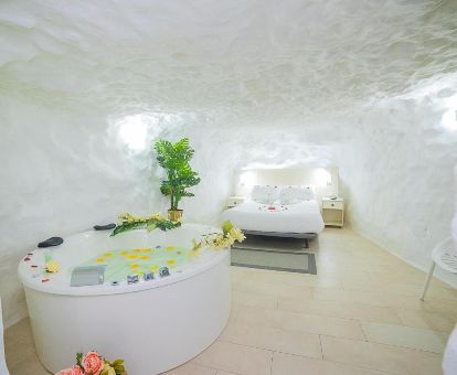 Coqueta habitación de tipo cueva con jacuzzi privado junto a al cama de este alojamiento romántico.