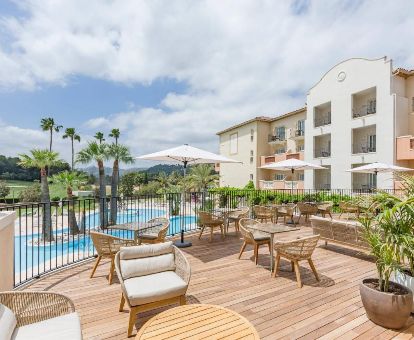 Romántico hotel con amplia zona exterior con mobiliario y piscina al aire libre.
