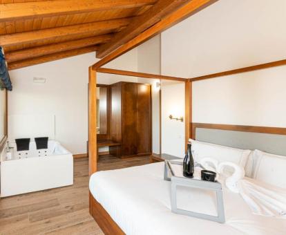 Dormitorio con bañera de hidromasaje privada junto a la cama del apartamento deluxe del hotel.