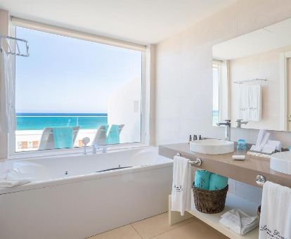 Baño con bañera de hidromasaje privada y vistar al mar de la habitación deluxe de este moderno hotel.