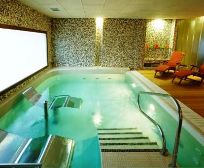 Foto de la piscina con elementos de hidroterapia del spa.