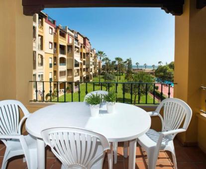 Foto del balcón con comedor exterior y vistas al mar de uno de los apartamentos.