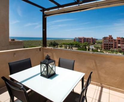 Foto de la terraza con vistas al mar y mobiliario exterior de uno de los apartamentos.