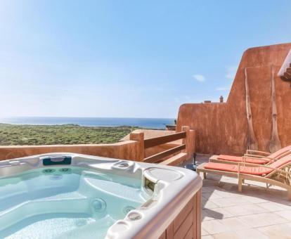 Foto de la terraza con vistas al mar y bañera de hidromasaje privada de uno de los áticos.