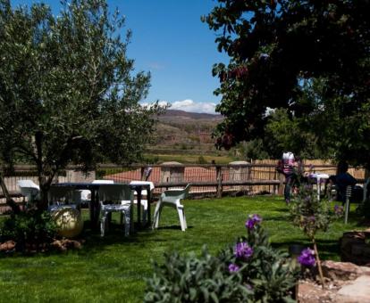 Foto del jardín de la casa con comedores al aire libre y vistas a la naturaleza.
