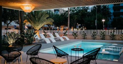 Terraza con tumbones en el interior y en el exterior junto al borde con una serie de mesitas para tomar una copa en pareja en el Instants Boutique Hotel