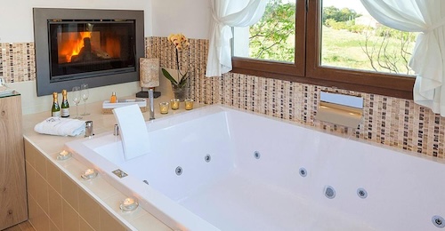 Jacuzzi frente a una chimenea y con vistas al campo en la suite superior de El Racó de Madremanya