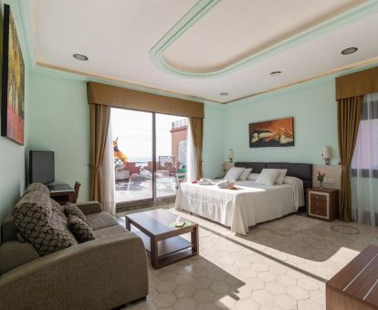Amplia suite deluxe con sala de estar y terraza privada de este hotel ideal para parejas.