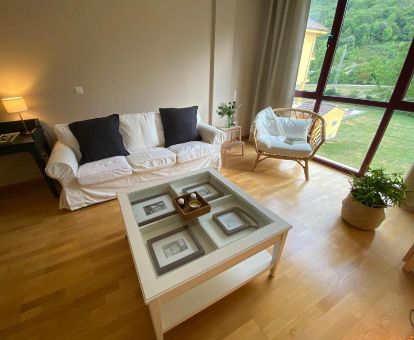 Sala de estar con amplios ventanales y vistas a la naturaleza de este apartamento independiente.