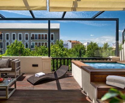 Maravillosa terraza con mobiliario y jacuzzi privado al aire libre de la suite ático del hotel.