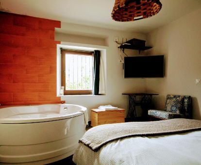 Bañera de hidromasaje privada junto a la cama de uno de los dormitorios de este alojamiento independiente.