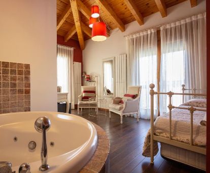 Acogedora habitación con bañera de hidromasaje privada junto a la cama de este hotel romántico.