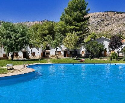 Complejo de bungalows en un tranquilo entorno natural con gran piscina al aire libre.