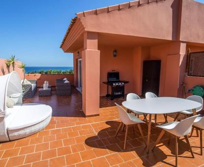 Foto de la fabulosa terraza con mobiliario exterior y barbacoa de este apartamento con vistas al mar.