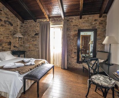 Una de las acogedoras habitaciones de estilo rústico con paredes de piedra a la vista de este hotel rural.