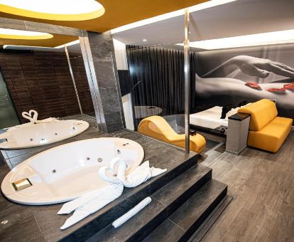 Suite con bañera de hidromasaje y sofá tantra de este elegante hotel para parejas.