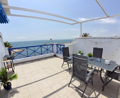 Foto de la amplia terraza amueblada con barbacoa y vistas al mar de uno de los apartamentos.