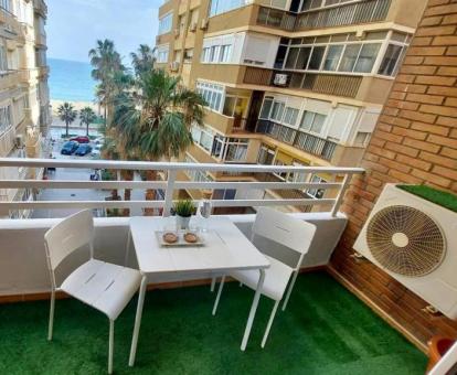 Foto del balcón con comedor exterior y vistas al mar de este apartamento.