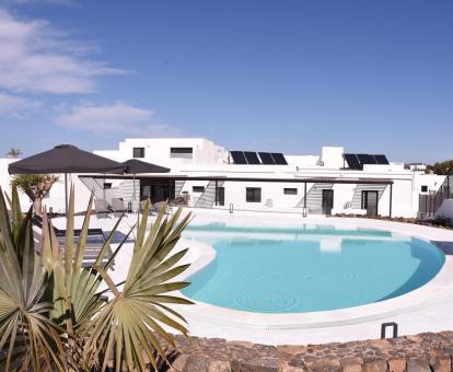 Foto del alojamiento con piscina al aire libre y elementos naturales.