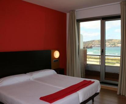 Foto de una de las habitaciones con balcón y vistas al mar del hotel.