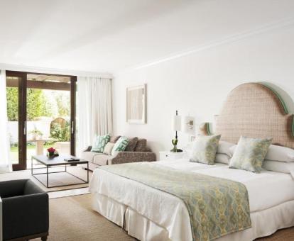 Foto de una de las elegantes habitaciones con sala de estar y terraza privada con acceso al jardín.