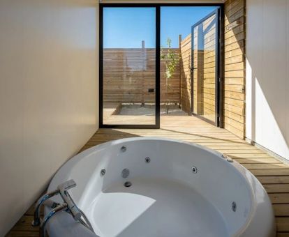 Bañera de hidromasaje privada con acceso a la terraza de una de las modernas villas de este establecimiento.