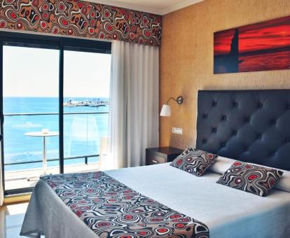 Foto de una de las coquetas habitaciones con terraza y vistas al mar del hotel.