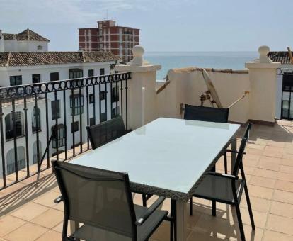 Foto de la amplia terraza amueblada con comedor exterior y vistas al mar del apartamento.