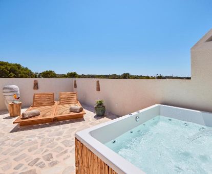 Terraza con un gran jacuzzi privado y tumbonas de la suite Sky del hotel.