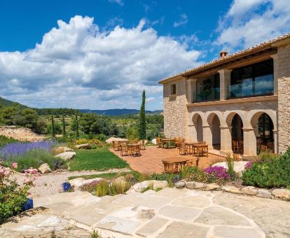 Edificio de este hotel con terraza con mobiliario y vistas a la naturaleza que lo rodea.