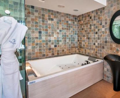 Bañera de hidromasaje privada de la suite con jacuzzi y jardín del hotel.