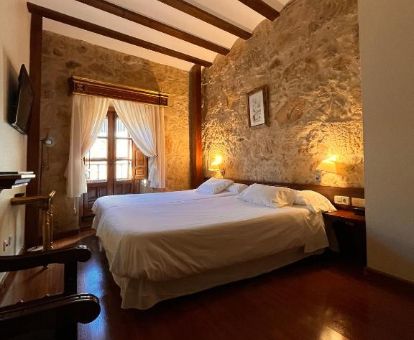 Una de las cómodas habitaciones dobles con paredes de piedra a la vista de este hotel solo para adultos.