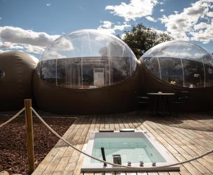 Habitación burbuja con terraza y jacuzzi en el exterior.