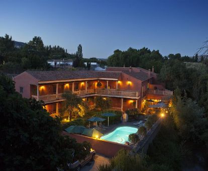 Edificio de este maravilloso hotel romántico con piscina, rodeado de vegetación.