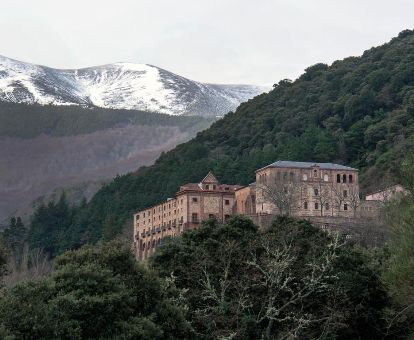 Monasterio en un tranquilo entorno rodeado de montañas y vegetación, ideal para descansar.