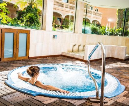 Mujer disfrutando del jacuzzi del centro de bienestar de este hotel romántico.