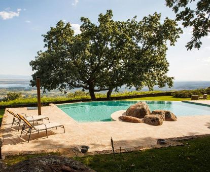 Hermosa zona exterior con piscina rodeada de vegetación de este maravilloso hotel ideal para parejas.