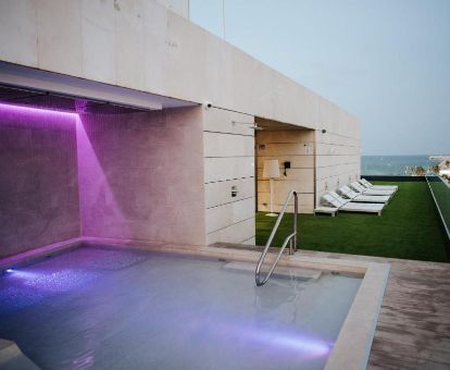 Agradable terraza con mobiliario, piscina exterior y vistas al mar del hotel.