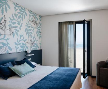 Foto de una de las alegres habitaciones del hotel con vistas al mar.