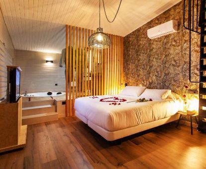 Preciosa Suite Deluxe con bañera de hidromasaje privada junto a la cama en este coqueto hotel para parejas.