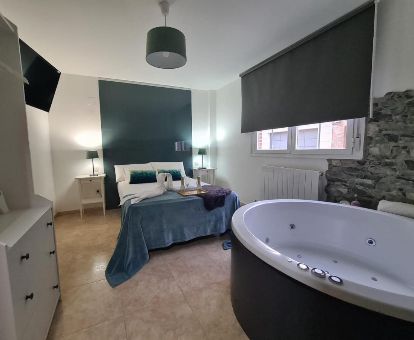 Dormitorio con una gran bañera de hidromasaje privada junto a la cama de este hermoso apartamento independiente.