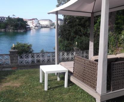 Foto de la zona ajardinada con mobiliario y vistas al mar del hotel.