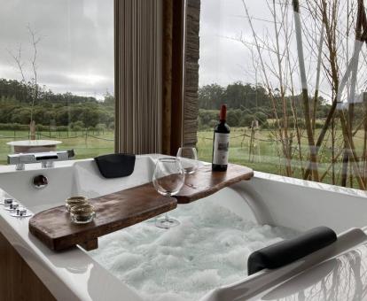 Bañera de hidromasaje privada para dos personas con vistas a la naturaleza de una de las suites del hotel.