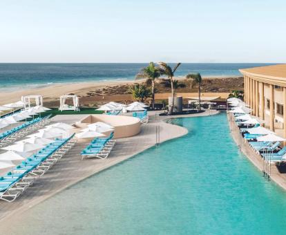 Foto de la piscina al aire libre del hotel con solarium y vistas a la playa.