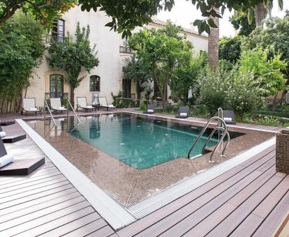 Foto de la piscina al aire libre disponible todo el año y rodeada de jardines de este hotel.