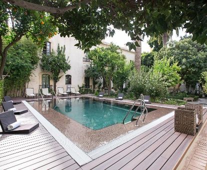 Hermosa zona exterior con piscina rodeada de vegetación de este elegante hotel.