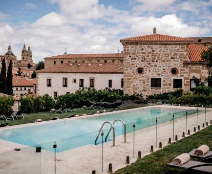 Amplia zona exterior ajardinada con piscina y vistas de este maravilloso hotel para parejas.