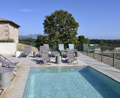 Agradable terraza solarium con piscina al aire libre y vistas a los alrededores de este hotel rural.