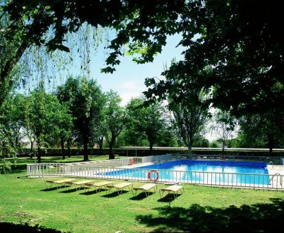 Foto de la piscina al aire libre rodeada de naturaleza de este parador.